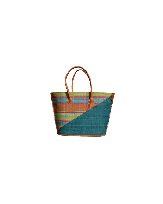 “Handmade raffia handbag from Madagascar featuring teal blue base with green, orange, and multicolor striped design, finished with leather handles and reinforced corners.”
