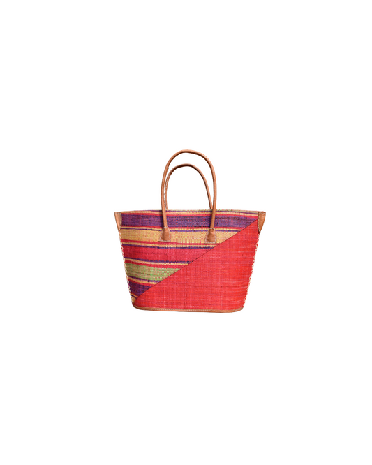 “Handmade raffia handbag from Madagascar featuring crimson red base with multicolored plum, yellow, and green stripes, finished with leather handles and reinforced corners.”