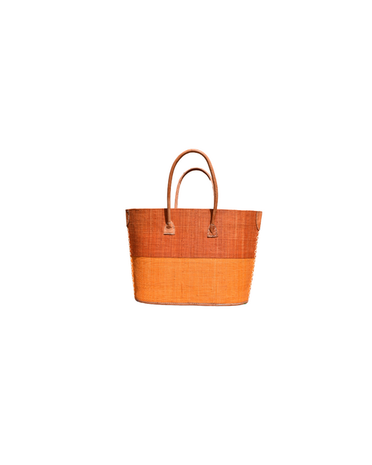 “Handmade medium raffia handbag from Madagascar with a two-tone amber-orange and golden-yellow base, finished with leather handles and reinforced corners.”